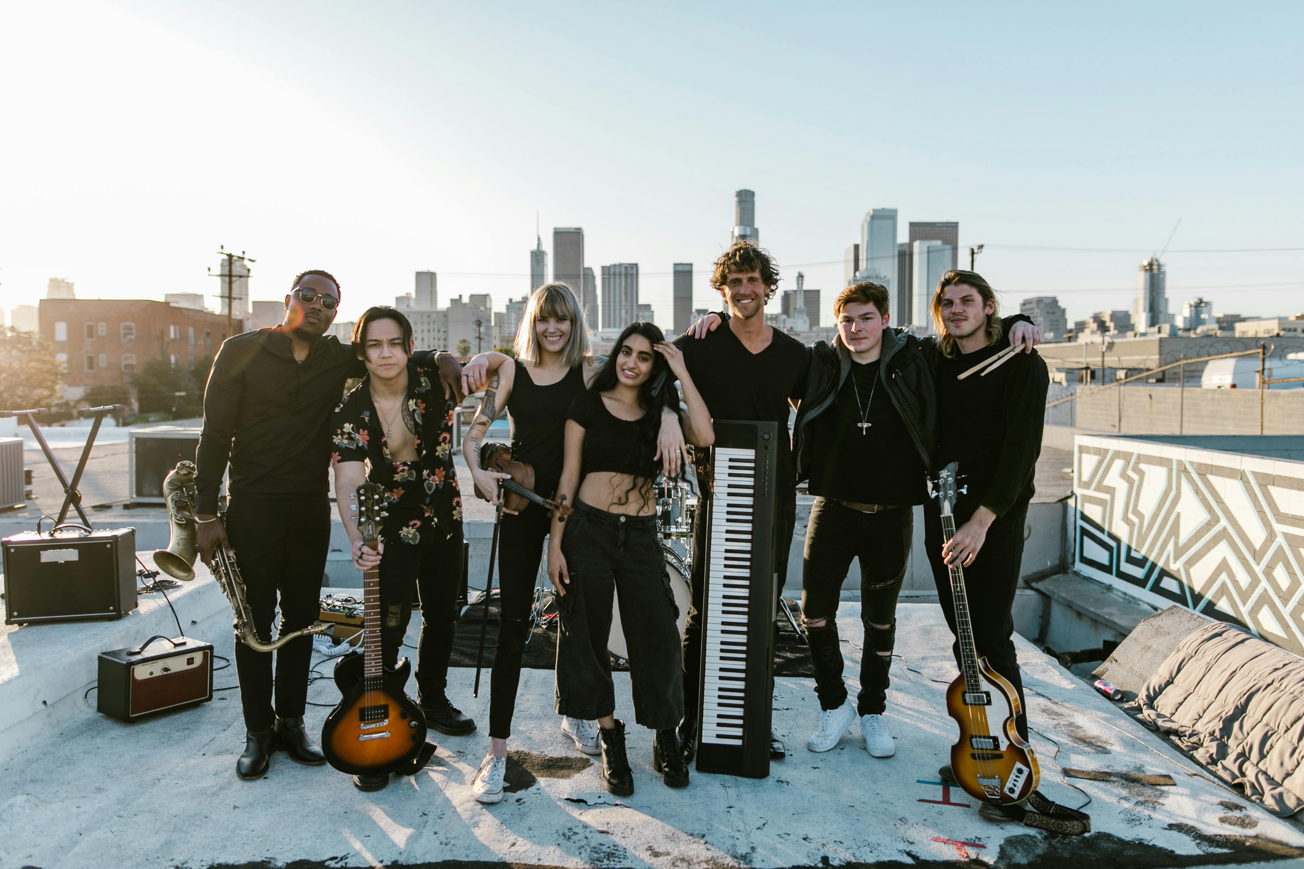 group photo of music band with instruments standing on the rooftop