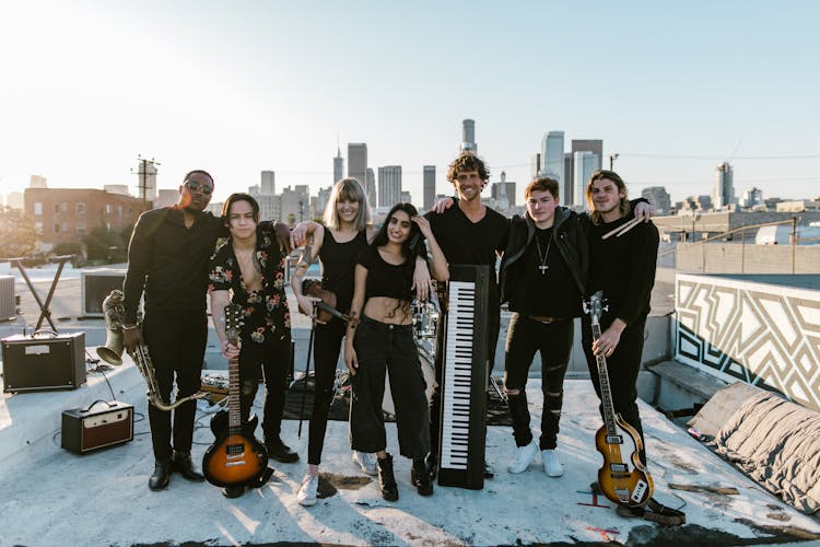 Group Photo Of Music Band With Instruments Standing On The Rooftop