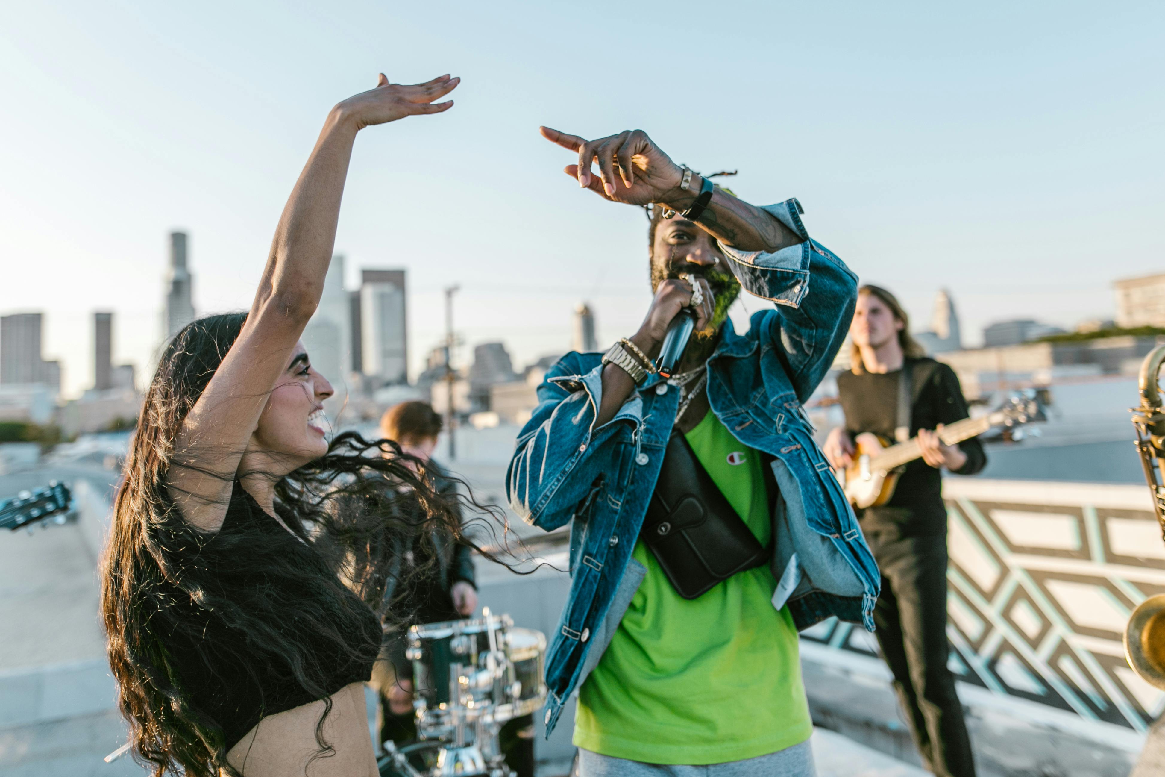 man in green t shirt singing beside smiling woman with raised hand