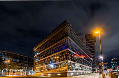 Free A stunning nighttime view of modern architecture in Düsseldorf with luminous street lights and cloudy skies. Stock Photo