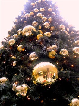 特写镜头中的圣诞树，装饰着闪闪发光的金色饰品和灯光