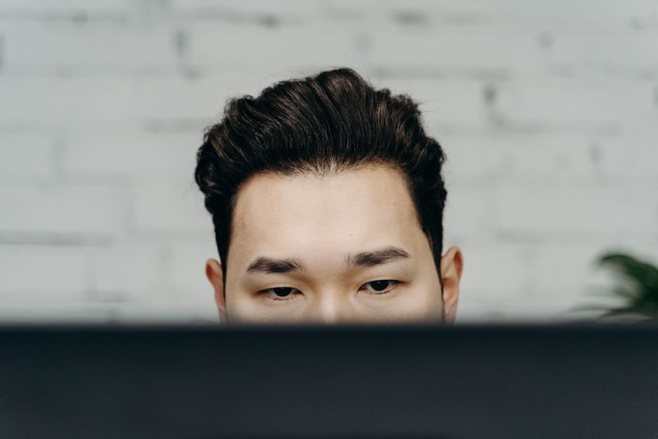 Close-up of a man intensely focused, working indoors in an office environment.