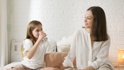 Free Mother and Daughter Sitting on the Bed Stock Photo