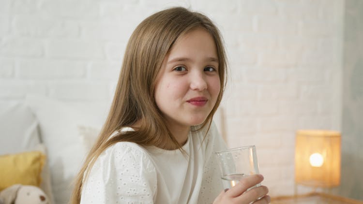 A Girl Holding A Glass Of Water