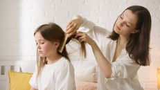 Woman in White Long Sleeve Shirt Holding Hair Brush