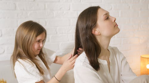 Free A Girl Braiding Her Mom's Hair Stock Photo