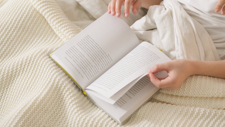 Photo Of A Person Flipping The Pages Of A Book