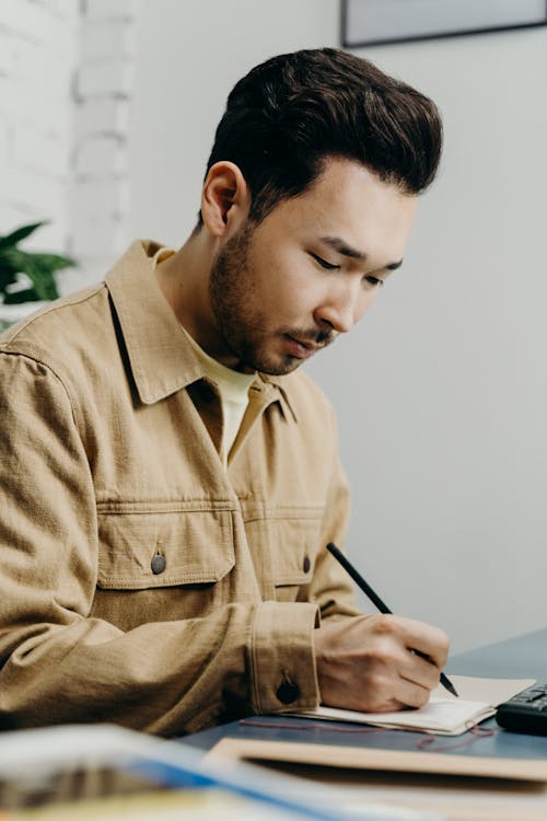 Man in Brown Button Up Jacket Holding Black Pen