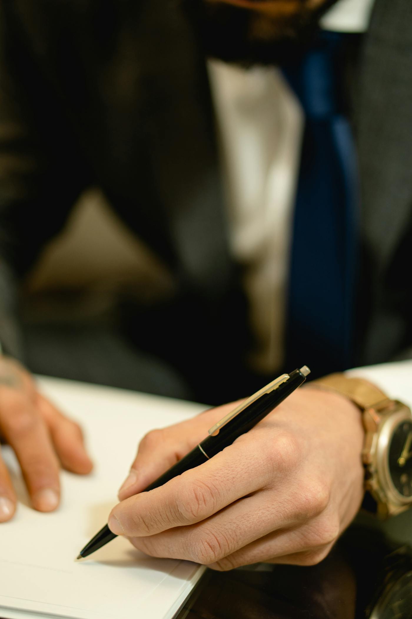 Primo piano di una mano che firma un documento su carta