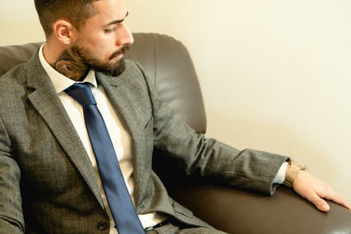 Photo of a Man with Facial Hair Wearing a Gray Suit