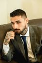 Man in Black Suit Jacket Sitting on Gray Couch
