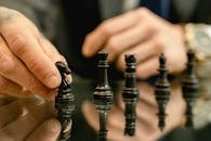 Person Holding Black Chess Piece