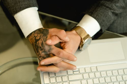 Person Resting his Hand on Top of Laptop