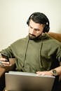 Man in a Green Hoodie Listening to Music