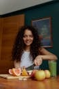 Photograph of a Woman Slicing Fruits