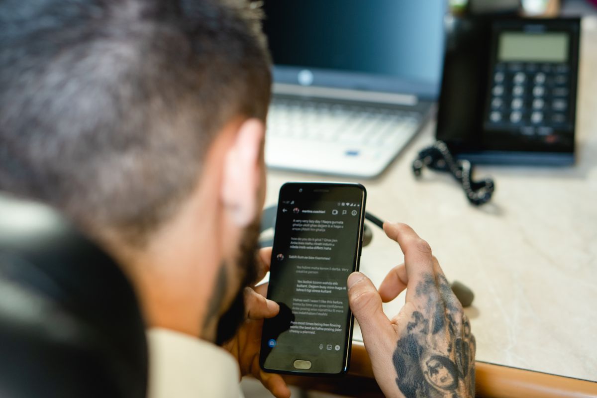 Why UAE inboxes are harder to triage Man checking messages on his phone at his desk
