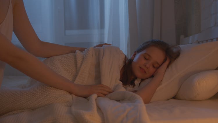 A Girl Sleeping On A Bed