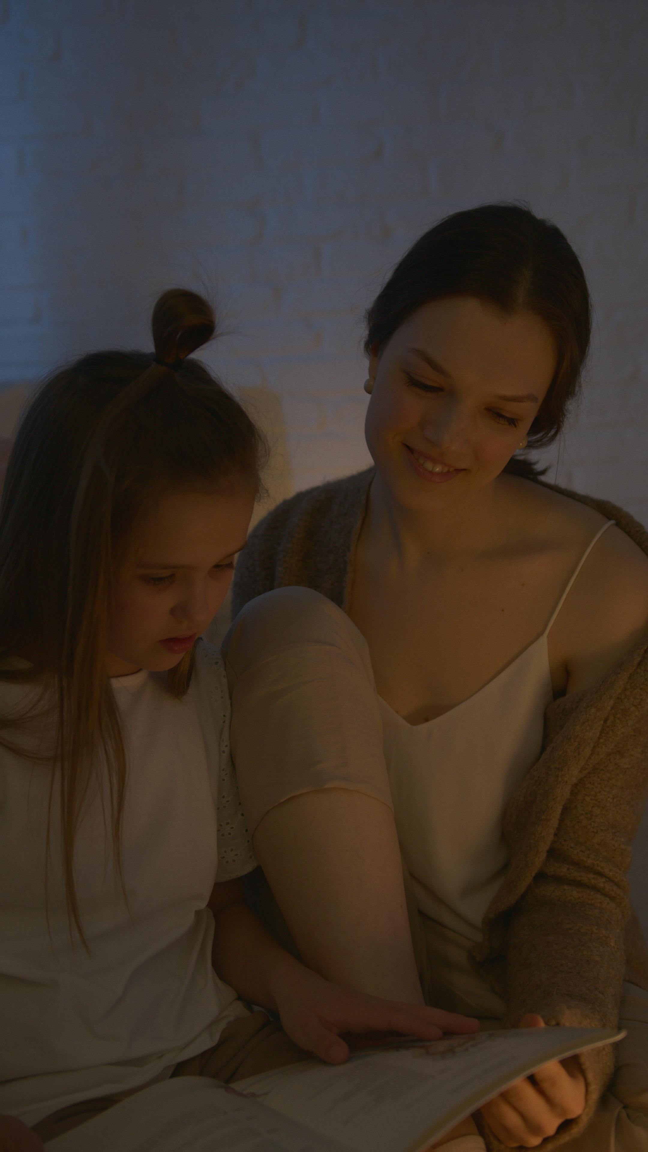 mother and daughter reading a book before bedtime