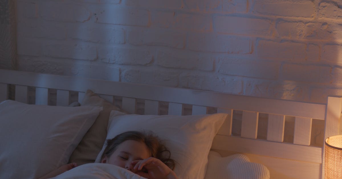 A child sleeps soundly in a warm, softly lit bedroom, wrapped in a cozy blanket.
