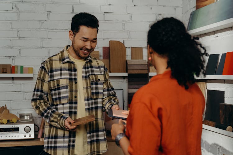 Smiling Salesman Showing Wood Samples To A Client