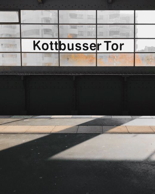 Sunlit view of Kottbusser Tor subway station in Berlin, Germany capturing shadows and architectural elements.