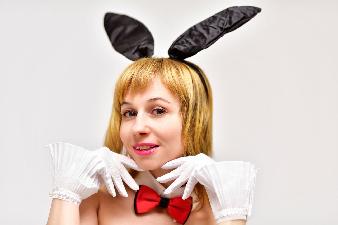 attractive female in headband with black rabbit ears wearing gloves an