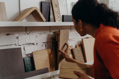 Woman Looking at Wood Samples on a Shelf