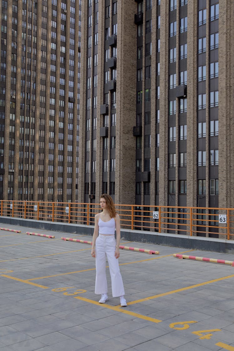 Woman In White Clothes Standing In A Parking Lot