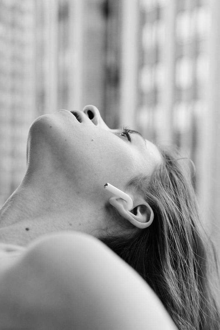 A Woman Listening From A Wireless Earphone