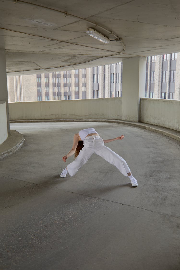 A Woman Dancing On A Parking Building Driveway