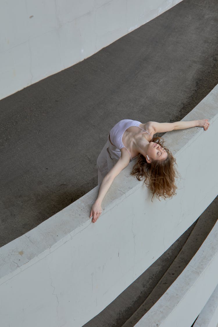 A Woman Leaning On A Parking Building Wall