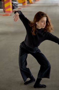 A contemporary dancer strikes a pose in a parking garage, showcasing fluid movement and expression.