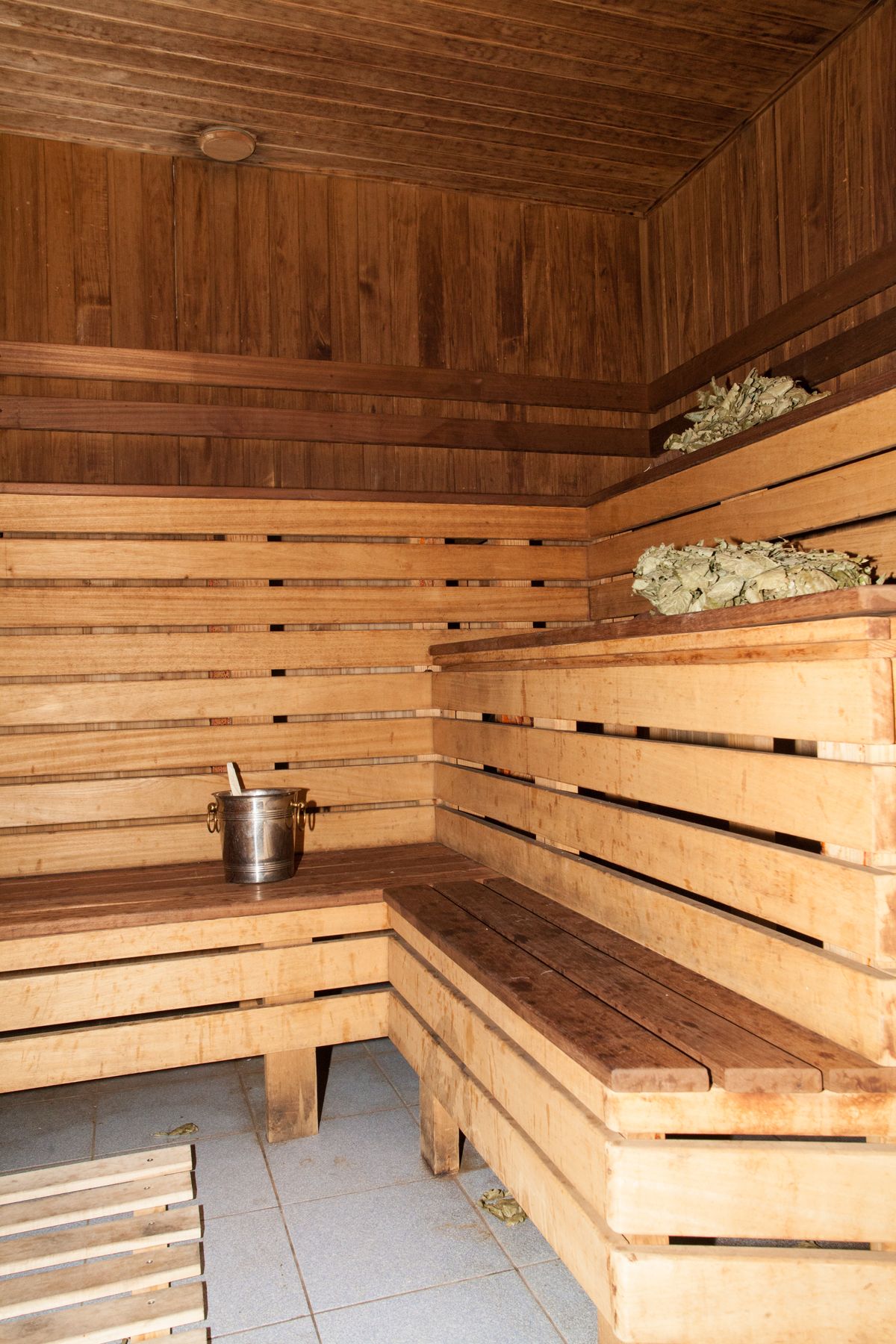 Interior de banya rusa tradicional con vihtas de abedul