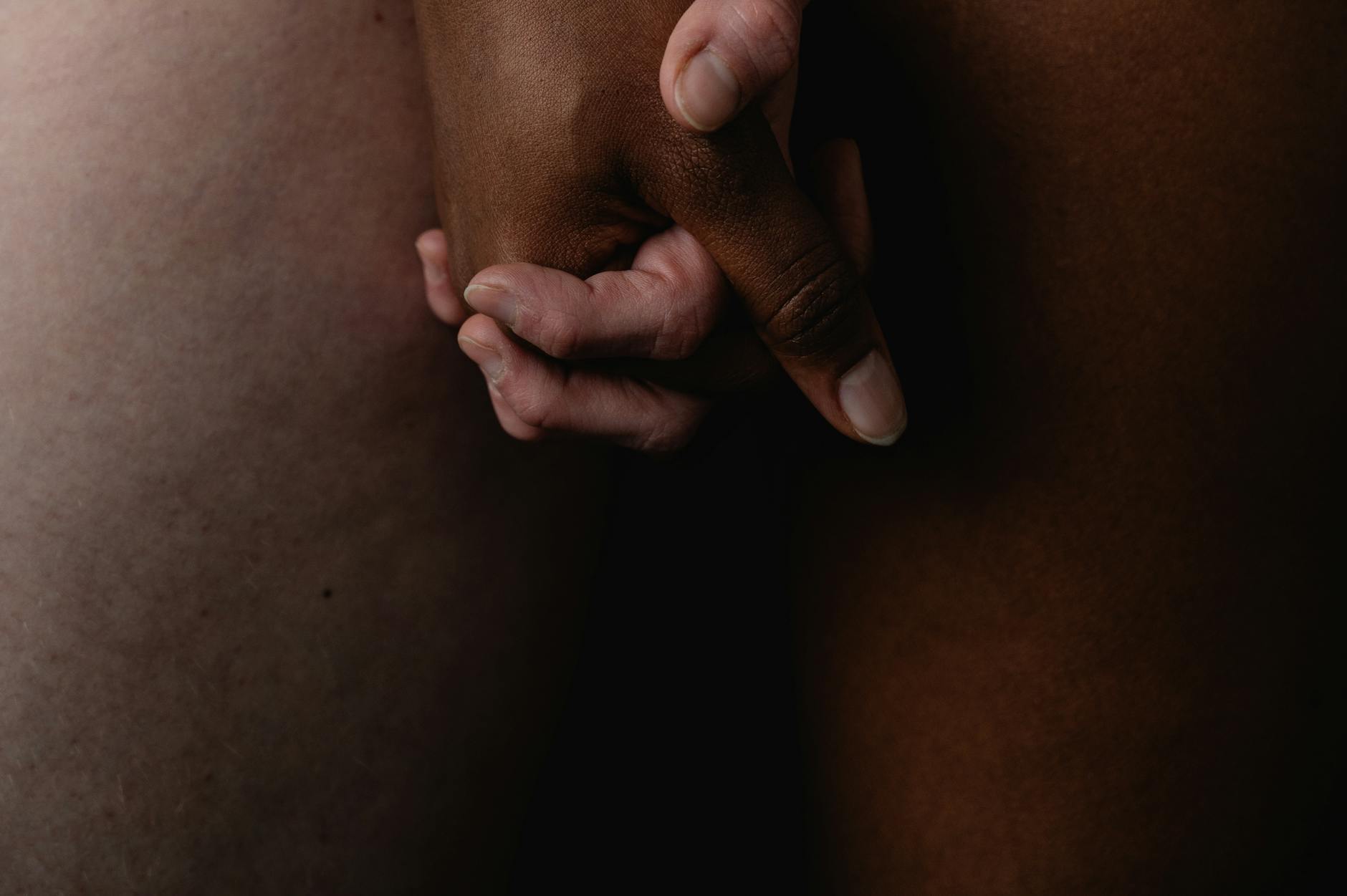Intimate close-up of diverse hands holding each other, symbolizing unity and connection.