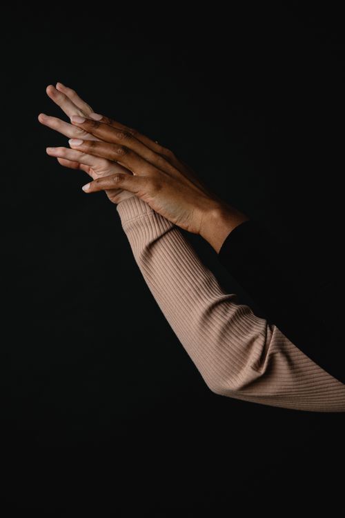 Free Hands reaching into the darkness, conveying connection and emotion. Stock Photo