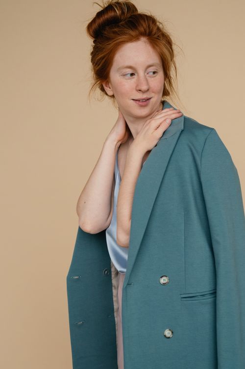 Free Elegant portrait of a redhead woman in a stylish blue jacket, exuding modern fashion and style. Stock Photo