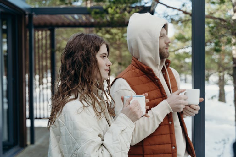 Man And Woman Holding Mugs