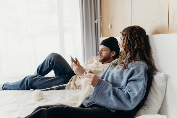 Woman Knitting Beside A Man