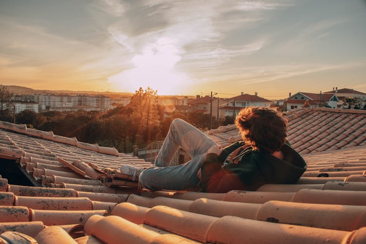 Person Lying On Rooftop Watching Sunset