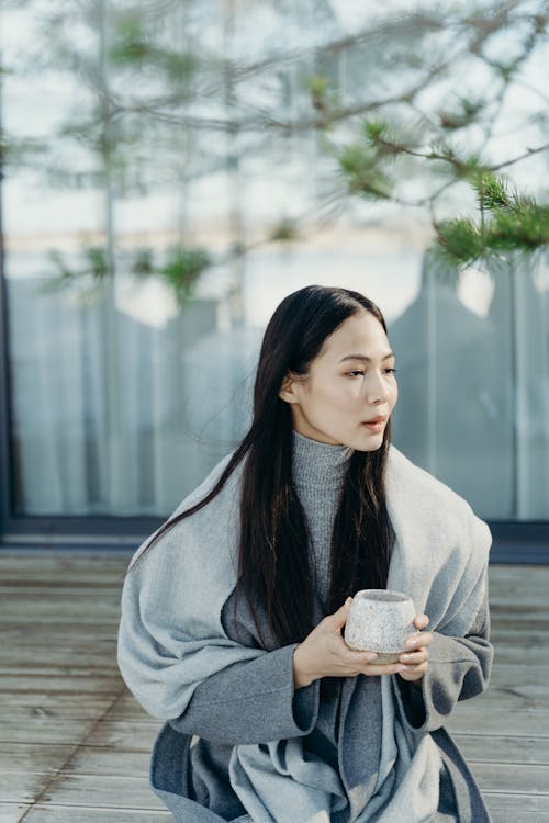 Free Woman Wearing Gray Scarf Holding a Cup Stock Photo