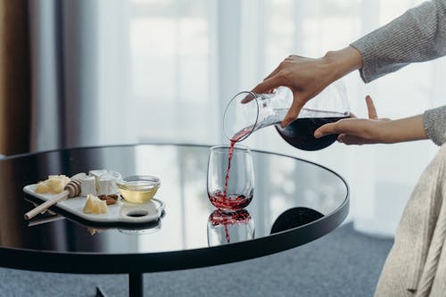 Person Pouring Wine in a Glass