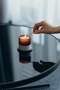 A Person Lighting a Candle with a Matchstick