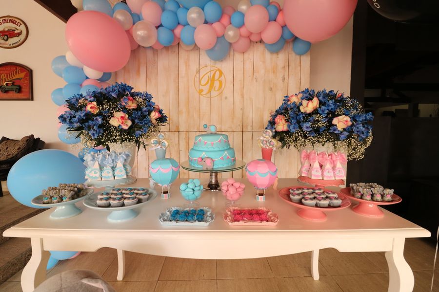 Gender reveal dessert table with blue and pink balloons