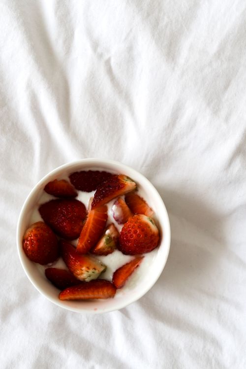 Free Flatlay of fresh strawberries and yogurt in a white bowl on a white surface, conveying a healthy and tasty meal. Stock Photo