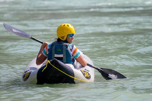 Person kayaking on a calm river in Rishikesh, enjoying an adventure under the sun.