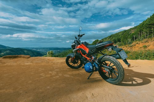Photography of Orange and Black Sports Motorcycle Near a Cliff