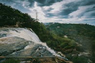 在阴云密布的天空下，瀑布从郁郁葱葱的青山间倾泻而下，景色令人惊叹