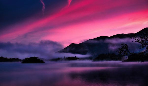 A captivating misty sunrise over a serene lake with pink skies and silhouettes of hills.