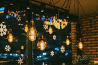 咖啡馆氛围温馨喜庆，悬挂着灯泡和雪花装饰