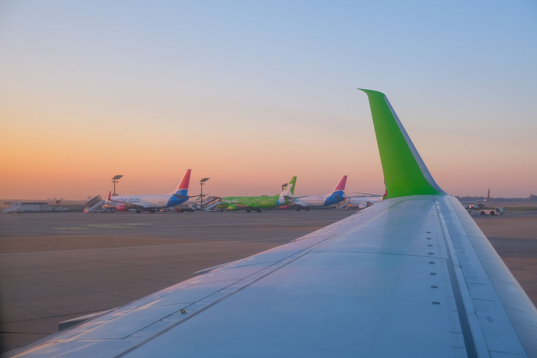American Airlines aircraft on the tarmac at sunset, as the carrier reported record Q2 revenue of $16.7B.
